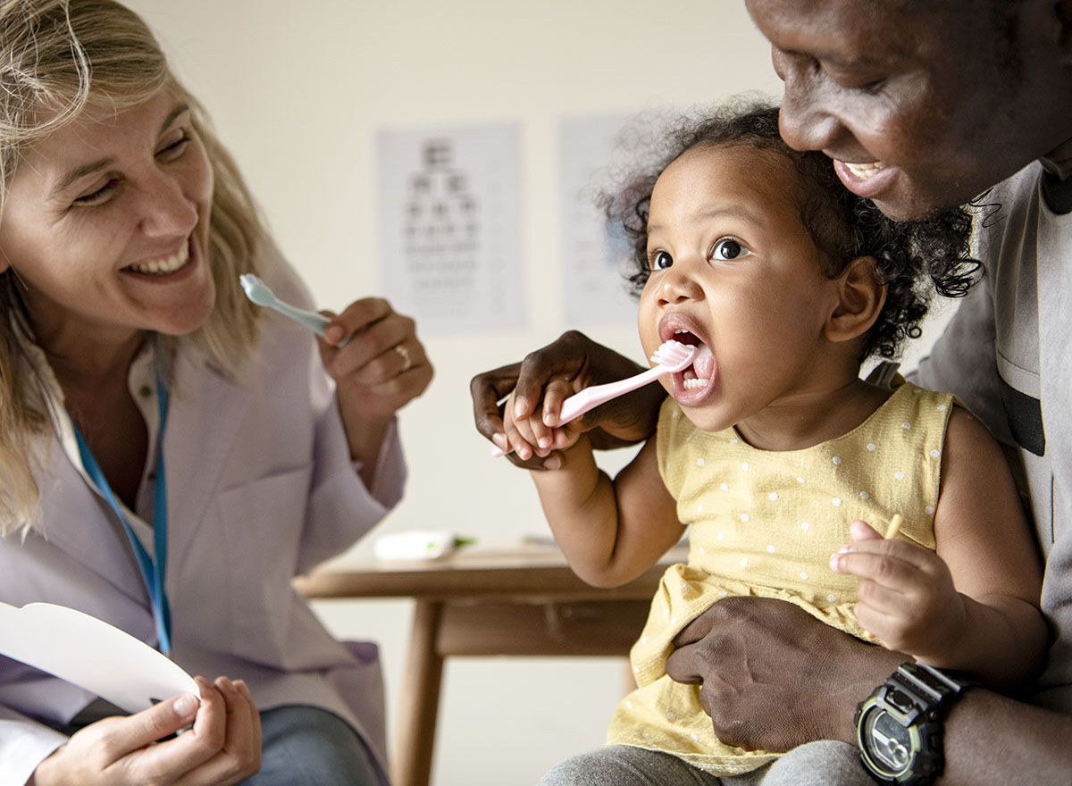 a dentist teaching a young child hot to prevent tooth decay