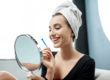 woman smiling in mirror after using at-home teeth whitening kits