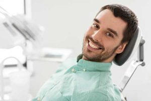 man smiling in dentist chair getting periodontics heights tx