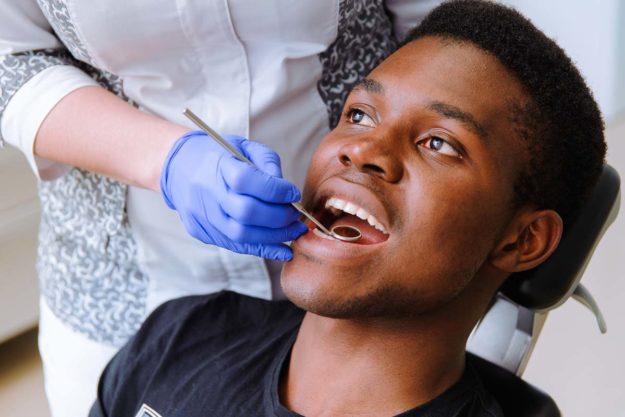 patient getting his teeth checked to prevent teeth from shifting