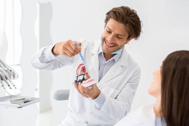 causes of receding gums (1) dentist explaining the causes of receding gums