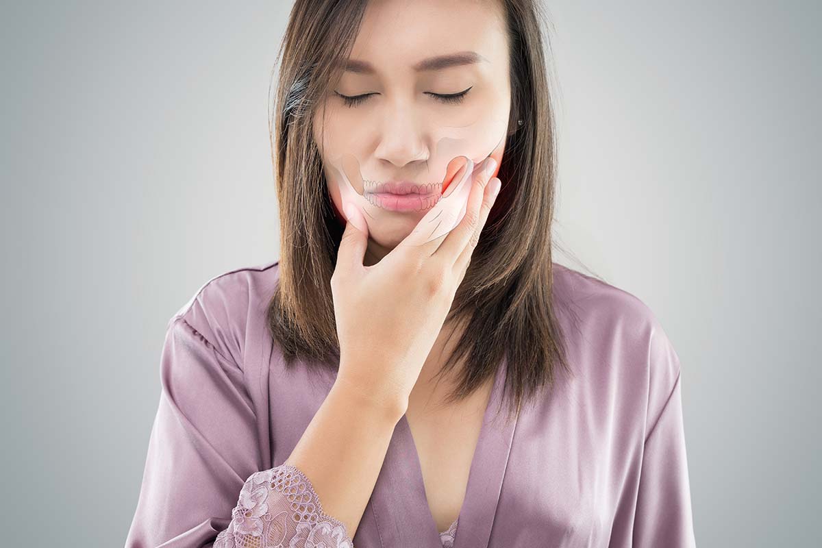 gums (2) woman holding her jaw because of gum pain